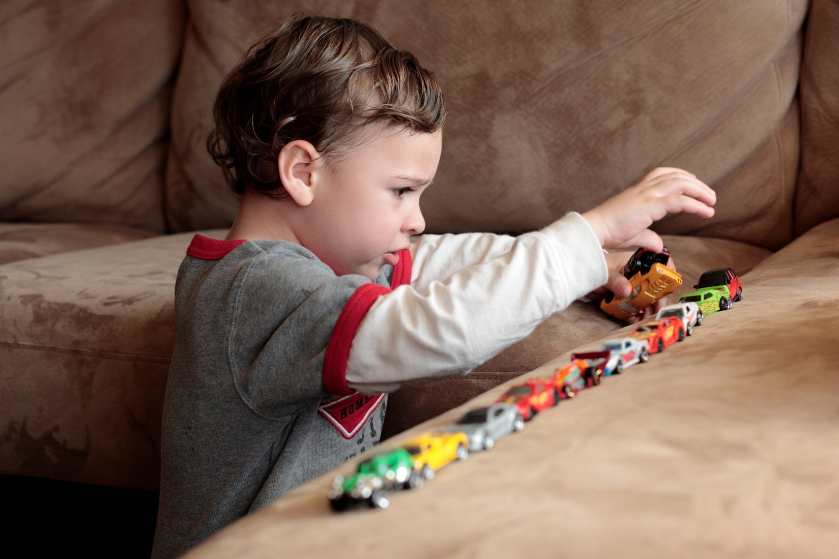 Autistic boy playing with toy cars