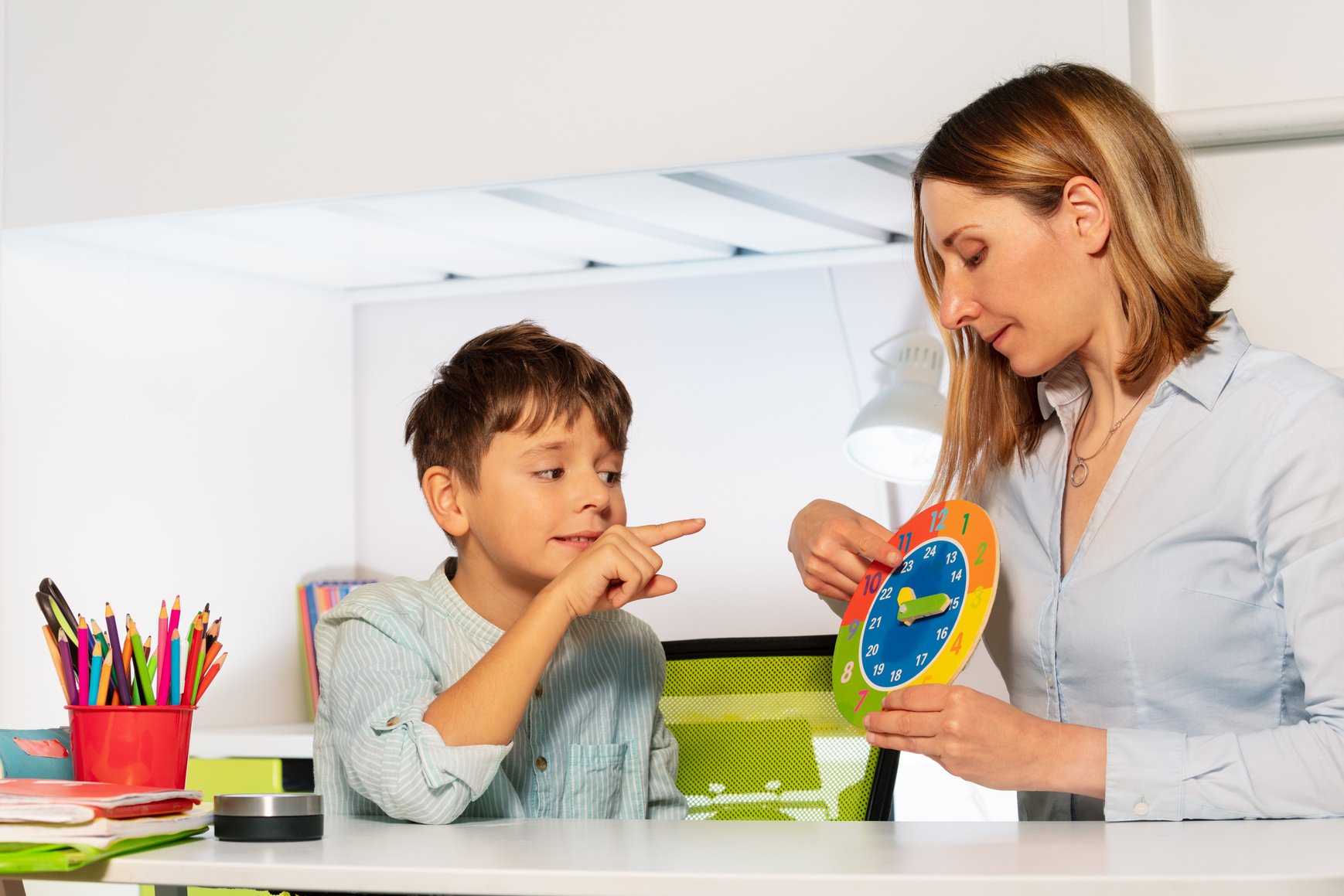 Boy with Autism and Teacher Learning Clock Together